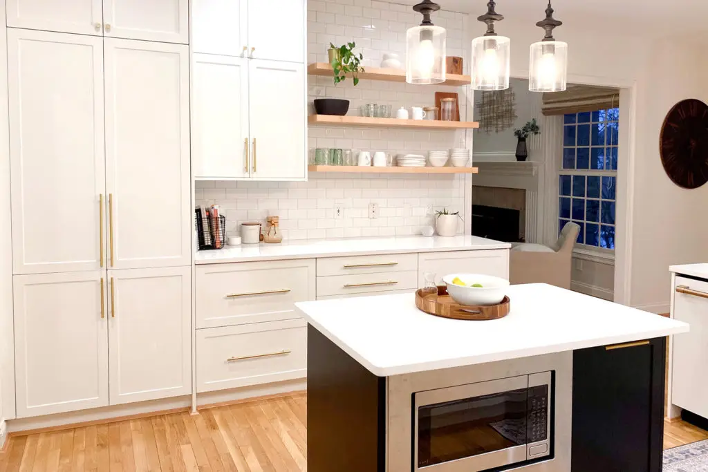 White Shaker wall cabinets and Black Shaker island in a kitchen remodel
